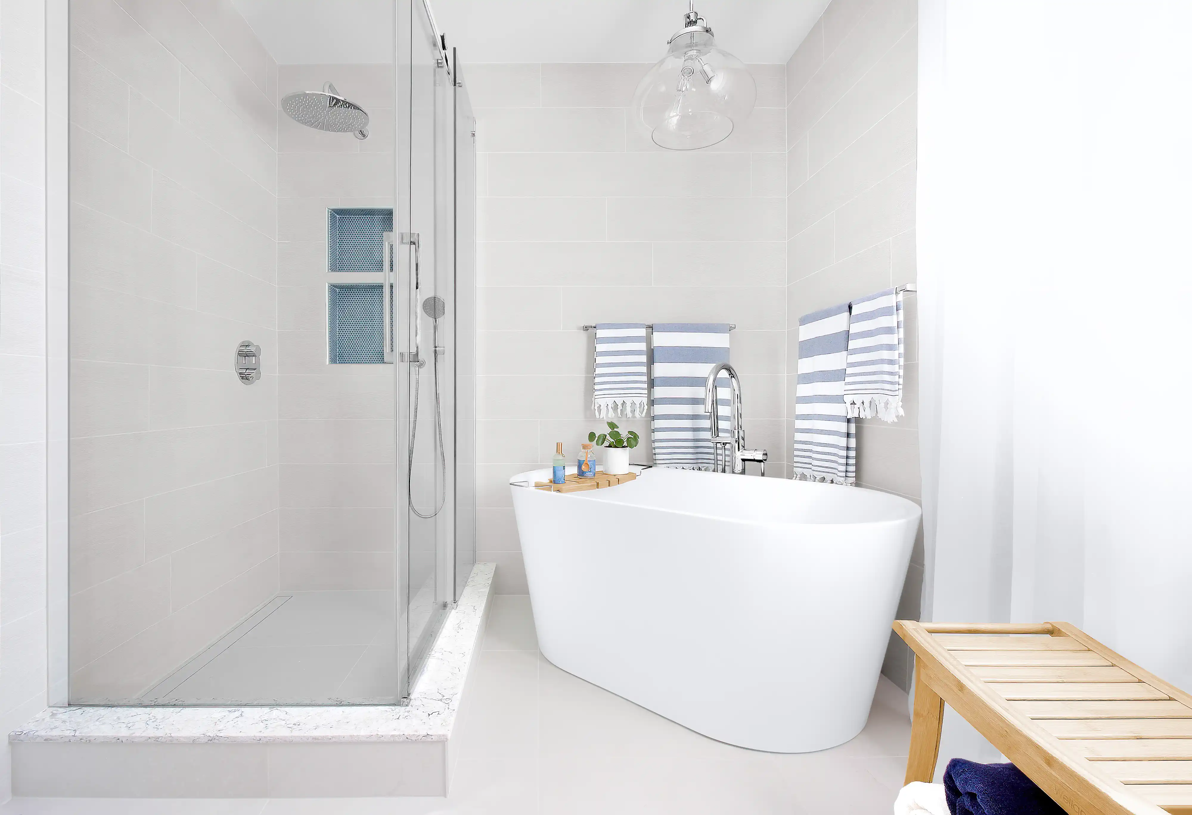 A modern bathroom with a white freestanding bathtub and a glass shower, interior by Sarah Brown Design