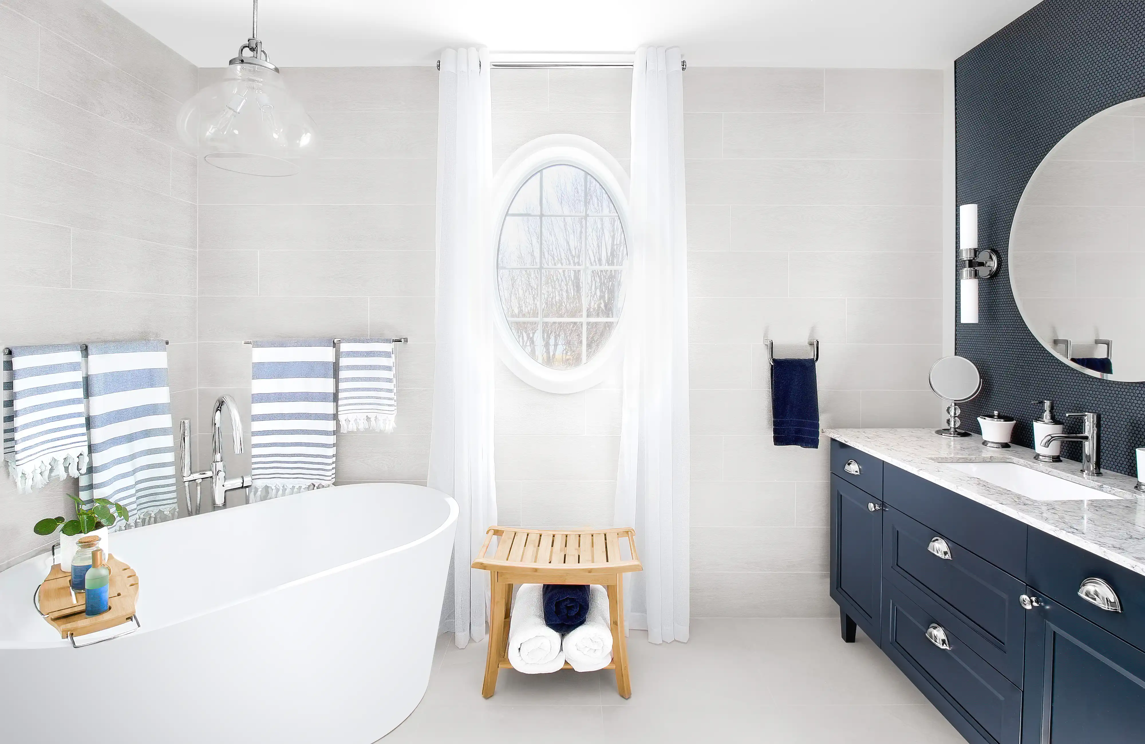 Une salle de bain blanche et bleue avec une baignoire sur pieds et un meuble-lavabo, intérieur signé Sarah Brown Design