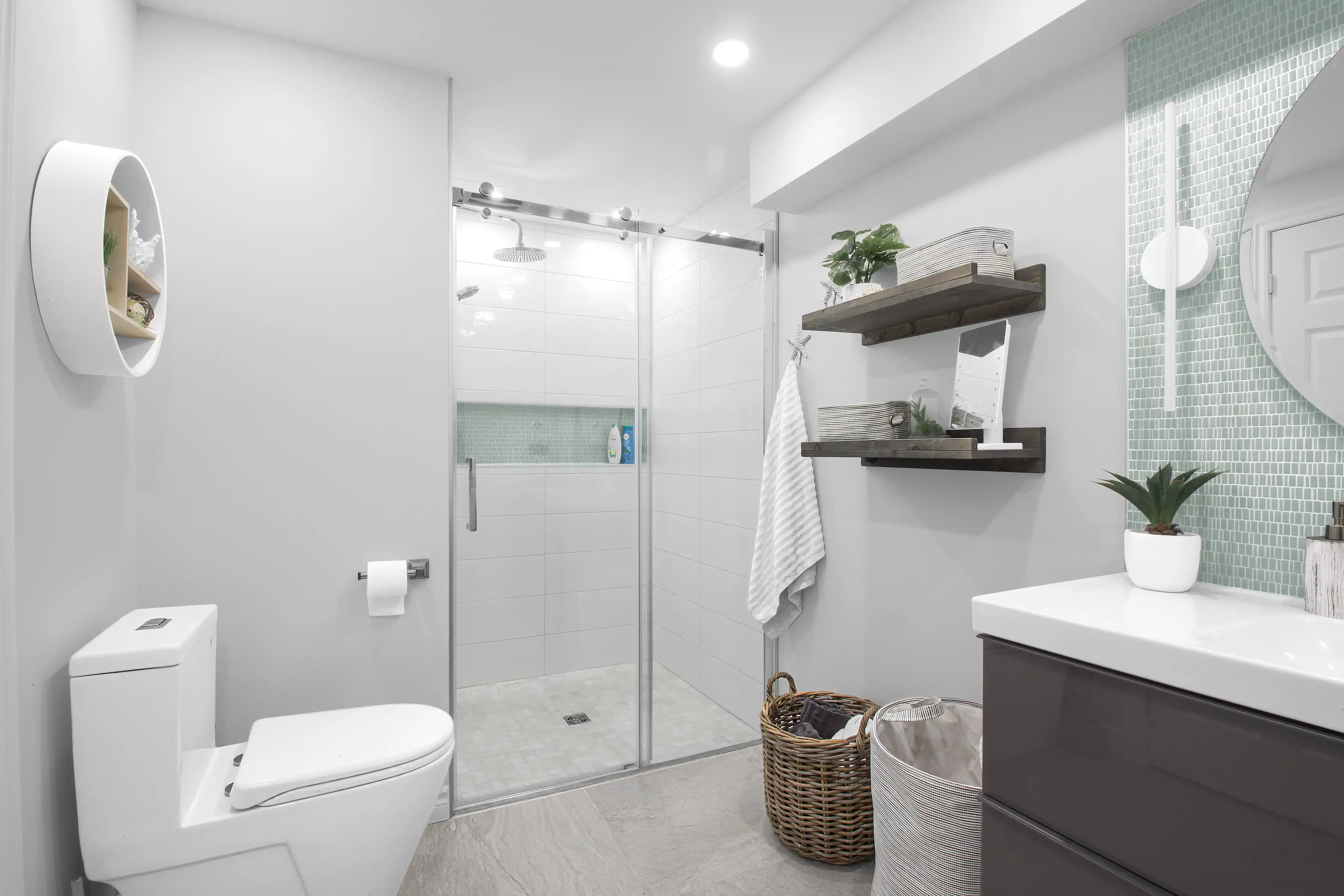 A modern bathroom with a shower, toilet, sink, and wooden shelves, interior by Sarah Brown Design