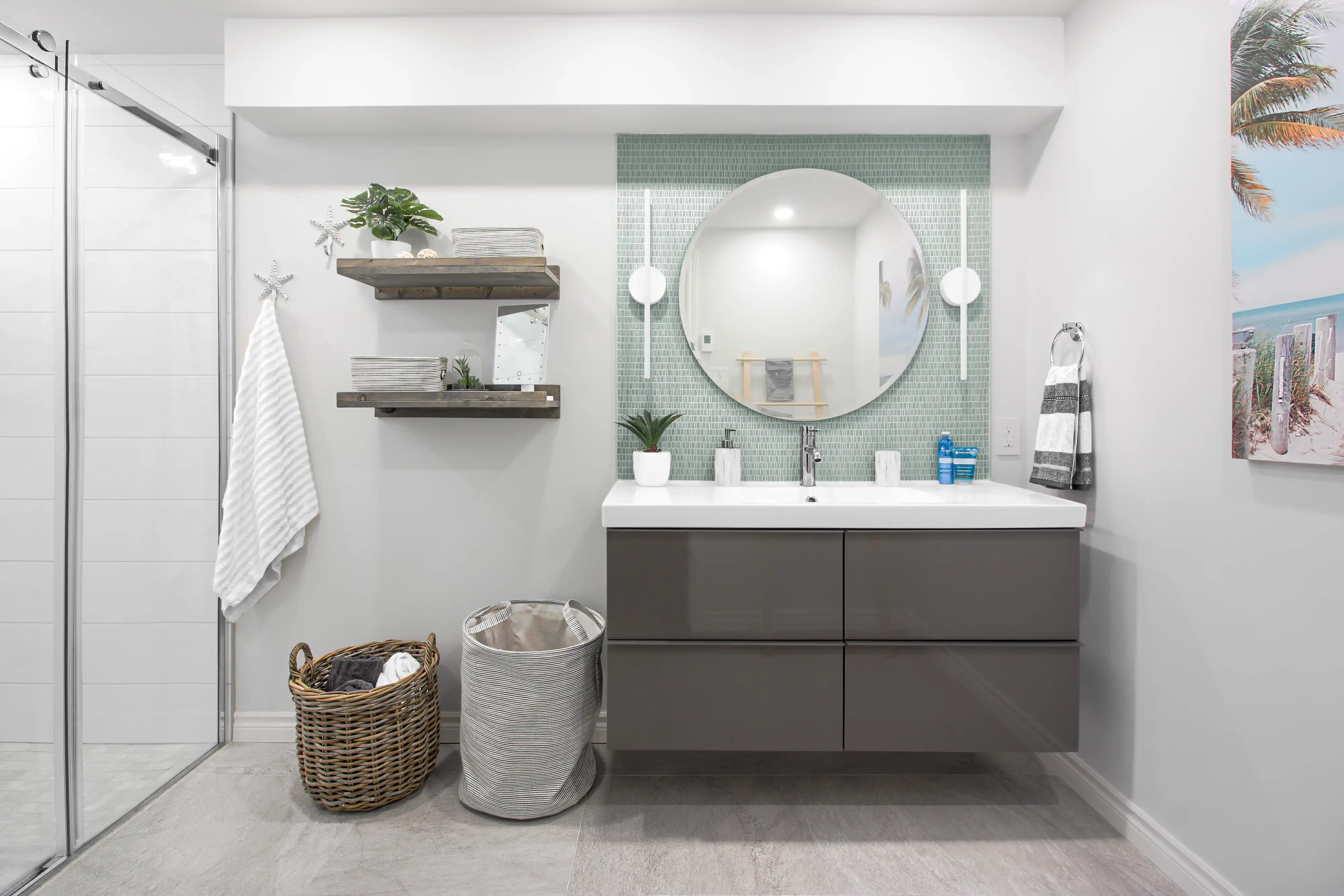 Une salle de bain moderne avec une douche, un lavabo, un miroir et des carreaux de mosaïque bleu-vert, intérieur signé Sarah Brown Design
