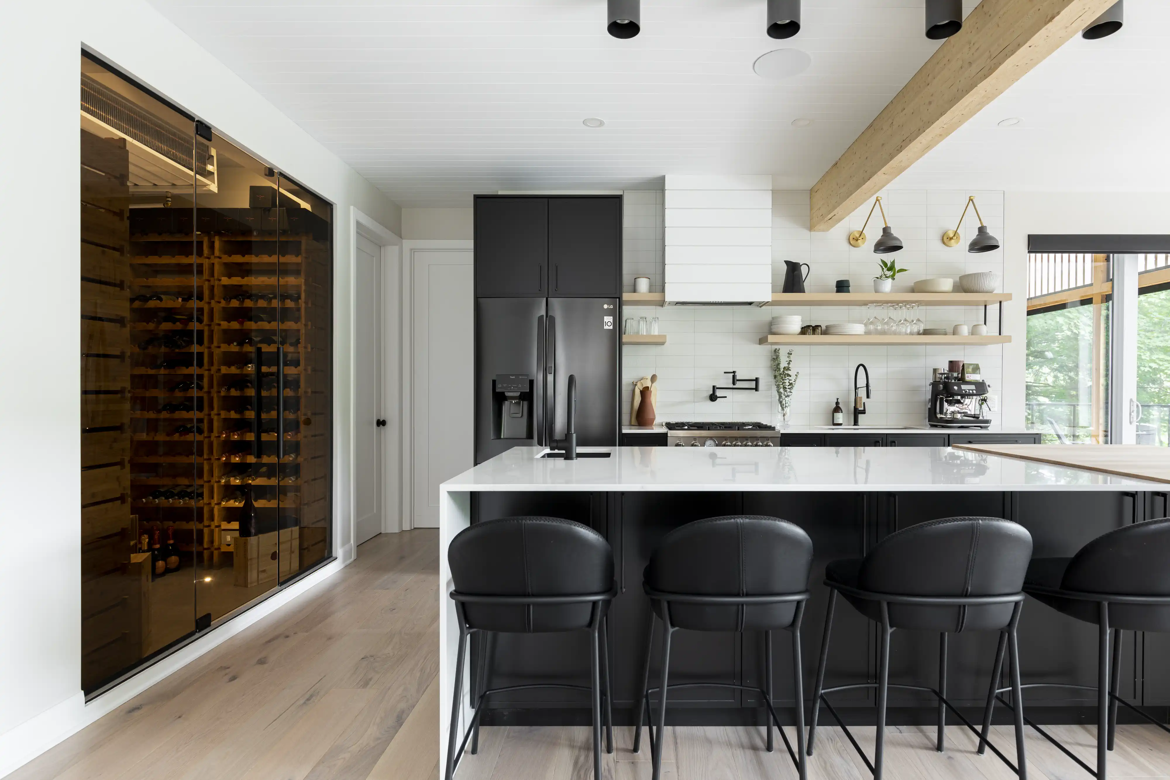 Une cuisine moderne avec une cave à vin et un schéma de couleurs noir et blanc, intérieur signé Sarah Brown Design