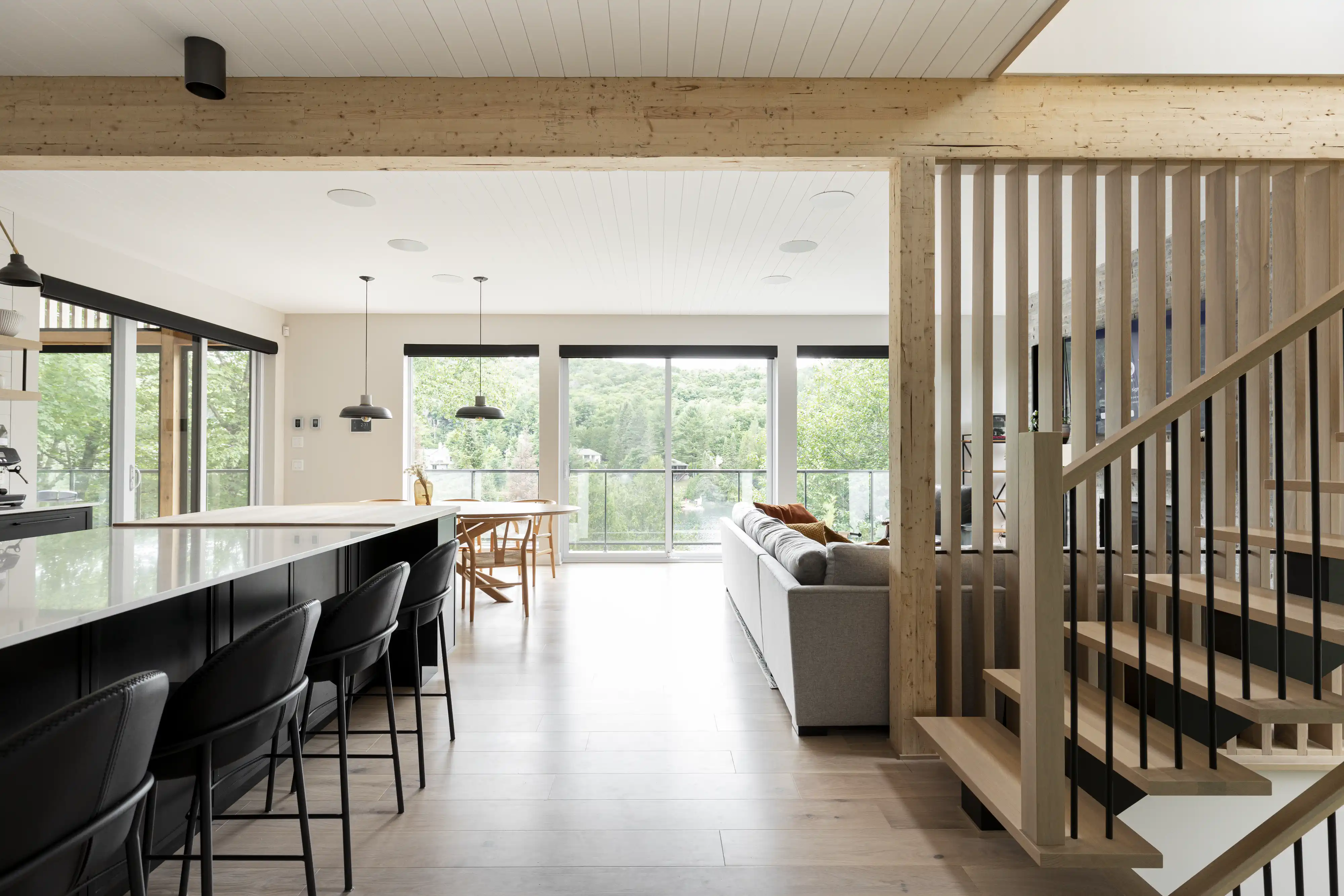 A modern kitchen and living room with a view of the outdoors, interior by Sarah Brown Design