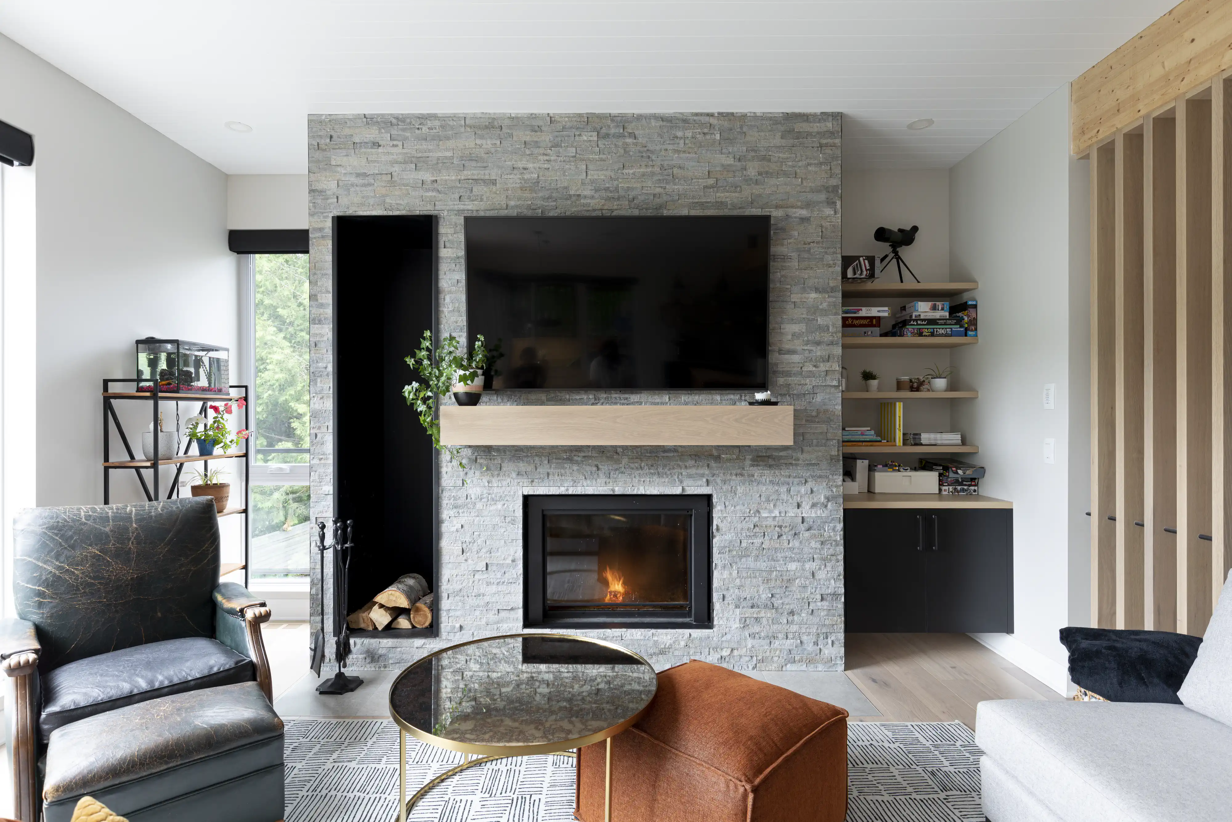 Un salon moderne avec une cheminée et une télévision, intérieur signé Sarah Brown Design