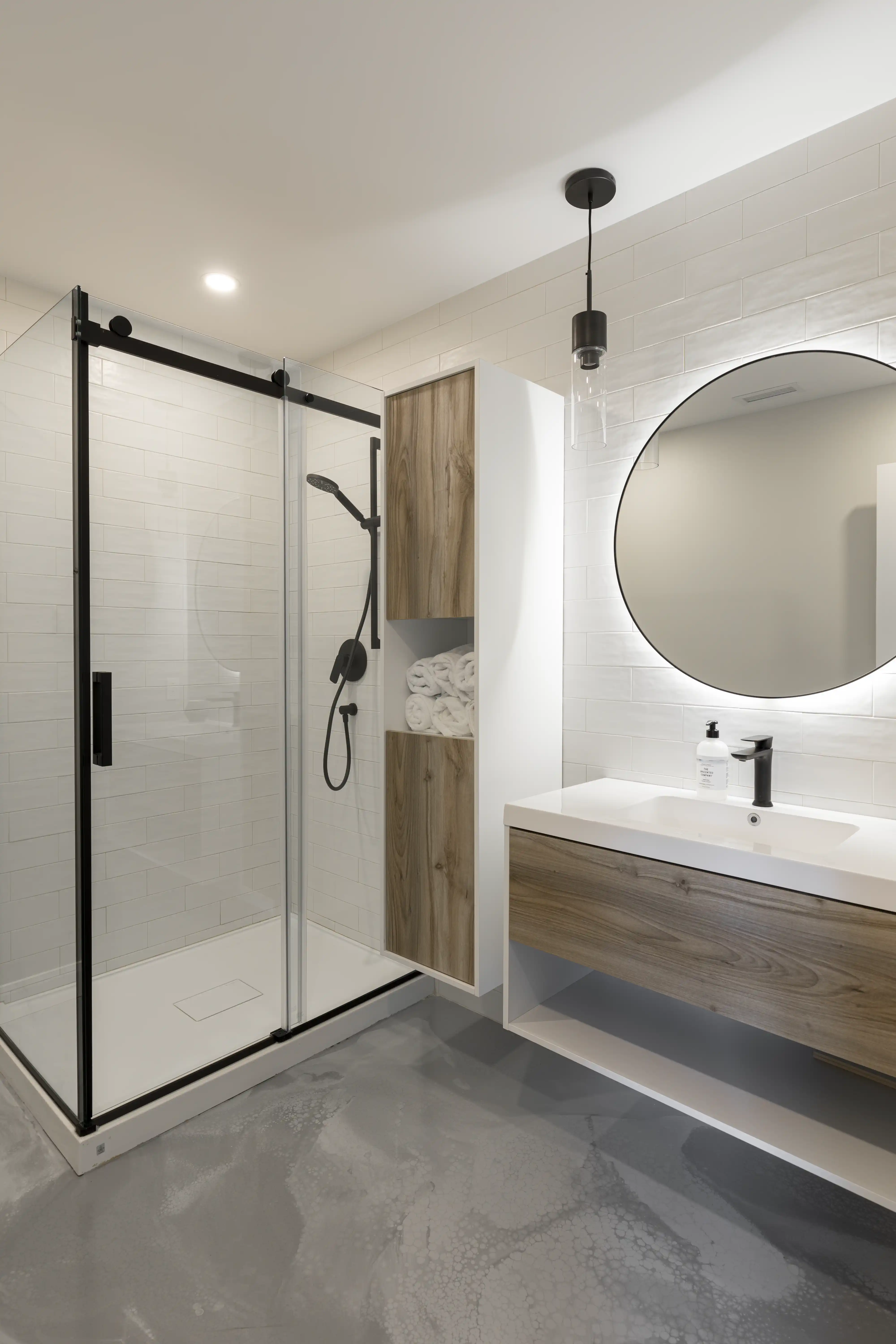 A modern bathroom with a shower and a sink in white and gray tones, interior by Sarah Brown Design
