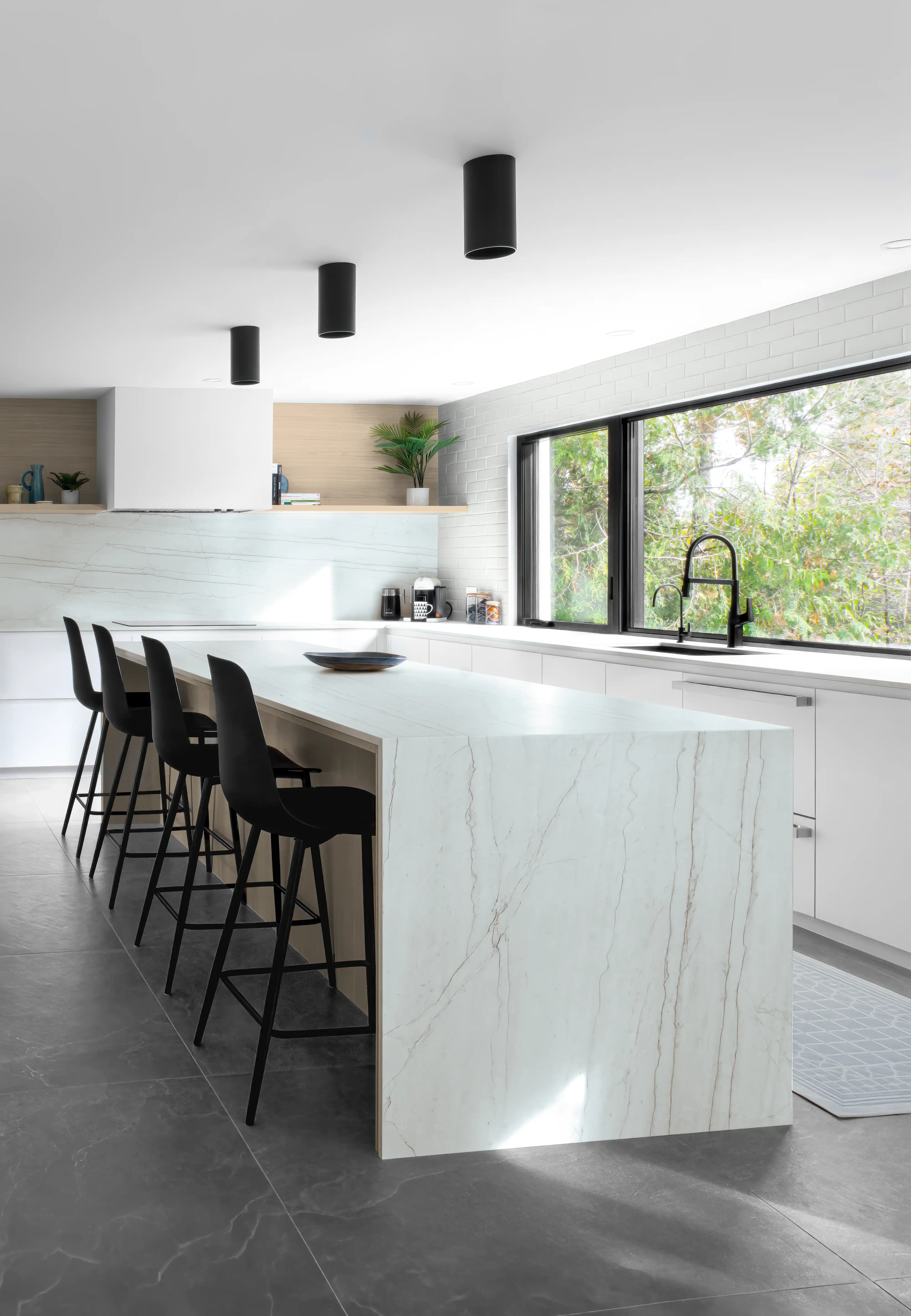 Modern kitchen with marble island, black bar stools, and sleek pendant lighting, interior by Sarah Brown Design