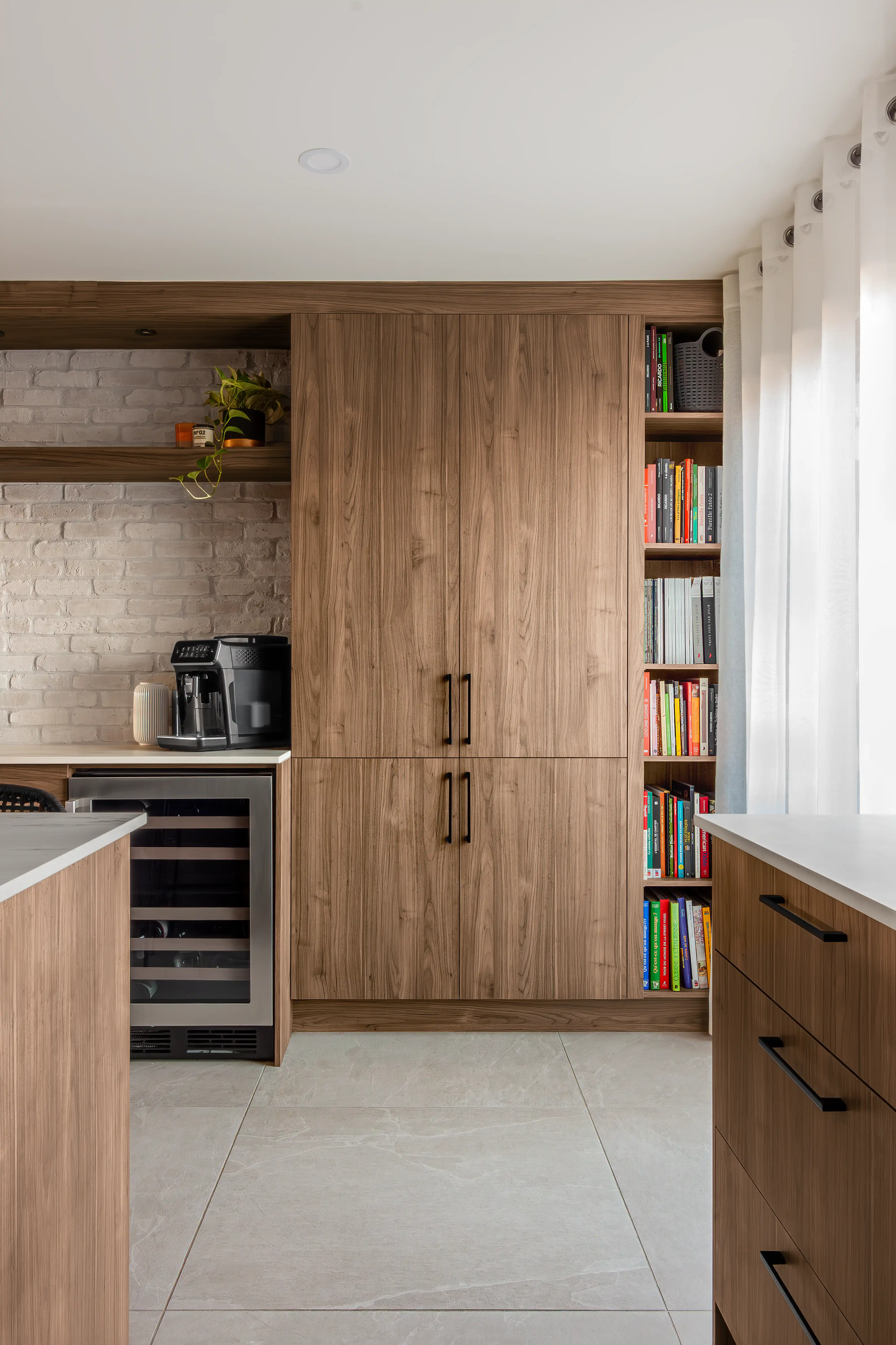 Kitchenette de style scandinave avec des armoires en bois et une bibliothèque intégrée aux appareils électroménagers, intérieur signé Sarah Brown Design