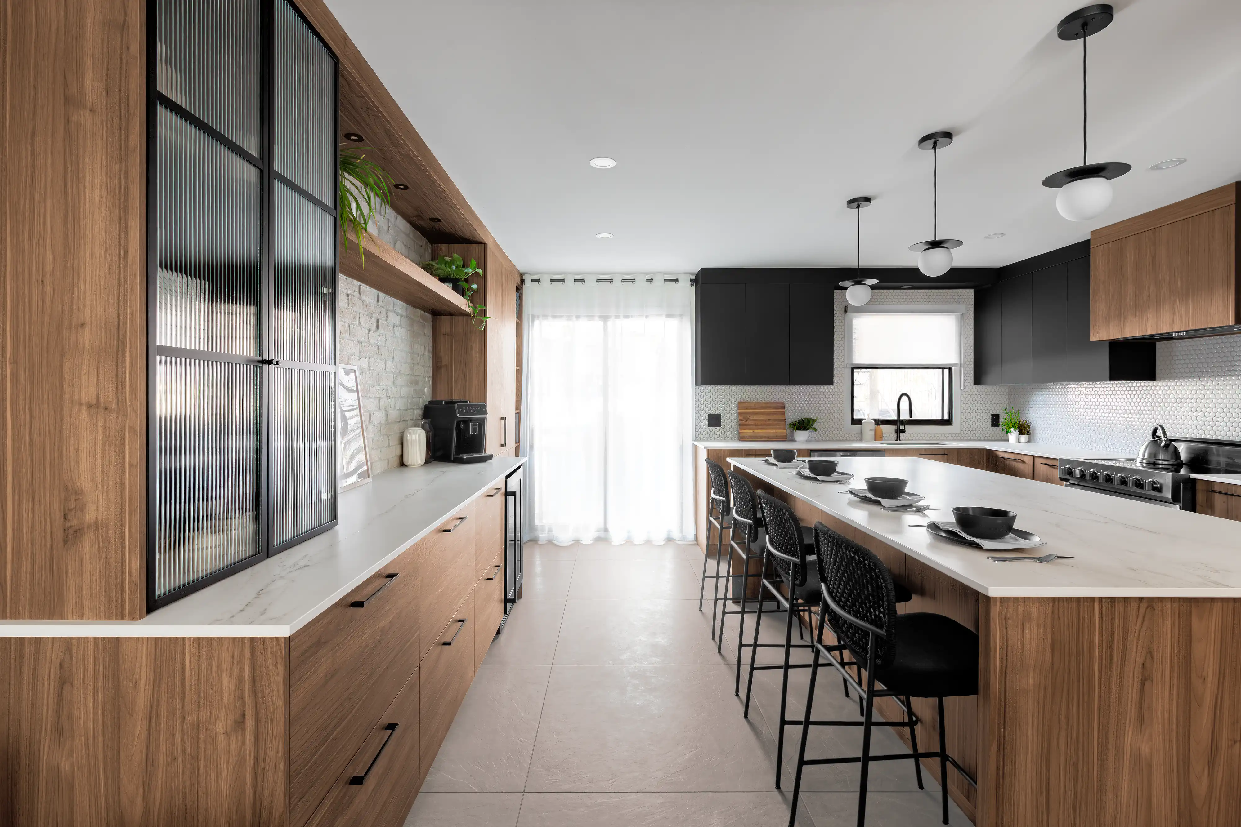 Spacious modern kitchen with wood finishes, fluted glass cabinets, and a long island countertop, interior by Sarah Brown Design